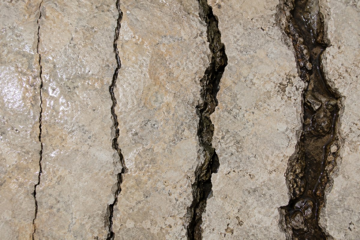 Quatro fendas de calcário com larguras diferentes e brilho de água, vistas de cima, sem números